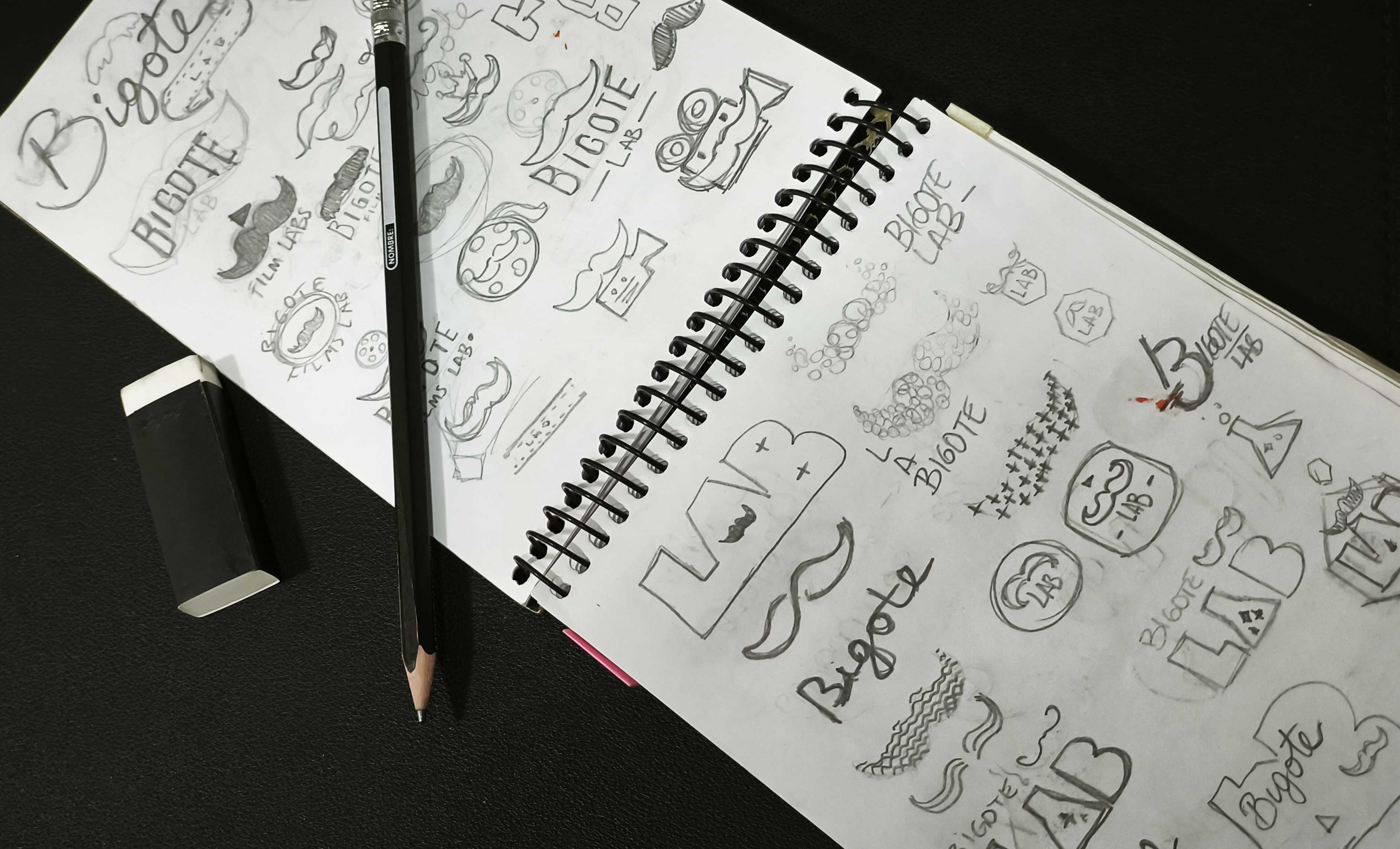 Página de bocetos a mano explorando el logo de Bigote Lab